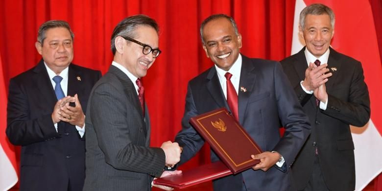 Menteri Luar Negeri Indonesia Marty Natalegawa berjabat tangan dengan Menteri Luar Negeri Singapura K Shanmugam disaksikan Presiden Susilo Bambang Yudhoyono dan PM Lee Hsien Loong.