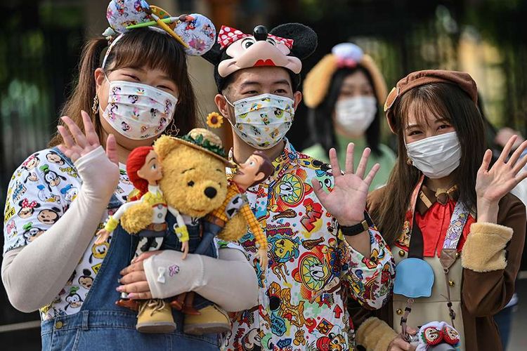 Pengunjung mengenakan masker saat mendatangi taman hiburan Disneyland, Shanghai, China, yang baru dibuka kembali, Senin (11/5/2020). Shanghai Disneyland resmi kembali dibuka setelah ditutup selama 4 bulan akibat pandemi virus corona.