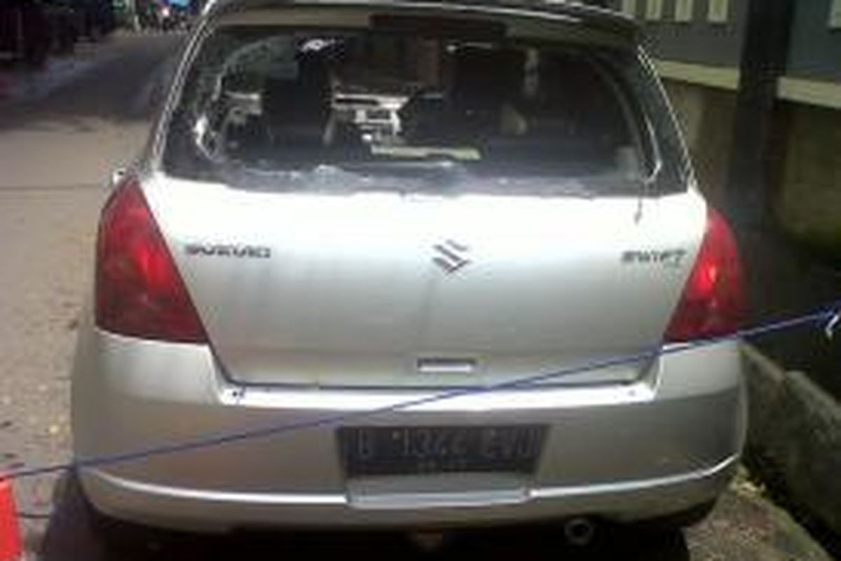 Mobil Suzuki Swift berwarna silver  dengan nomor B 1344 EVJ terparkir di depan Apartemen Cawang dengan kaca terpecah.
