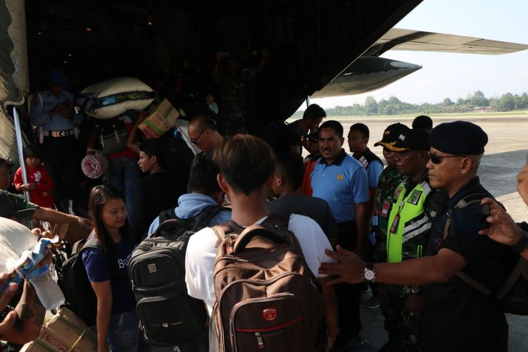 Para pengungsi yang akan kembali ke Wamena sedang antre masuk ke dalam pesawat Hercules di Base Ops Lanud Silas Papare, Jayapura, Jumat (11/10/2019).