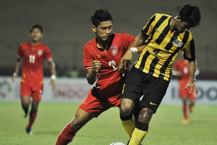 Pemain Malaysia dan Myanmar berebut bola pada laga final Piala AFF U-19 di Stadion Deltras Sidoarjo, Sabtu (14/7/2018).