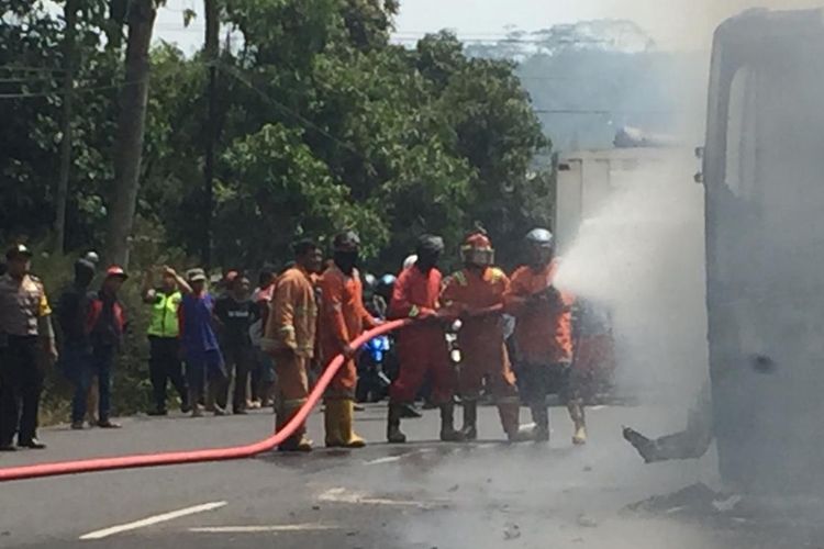 Pemadam kebakaran berupaya memadamkan api yang membakar Bus Joglosemar, Kamis (26/9/2019).