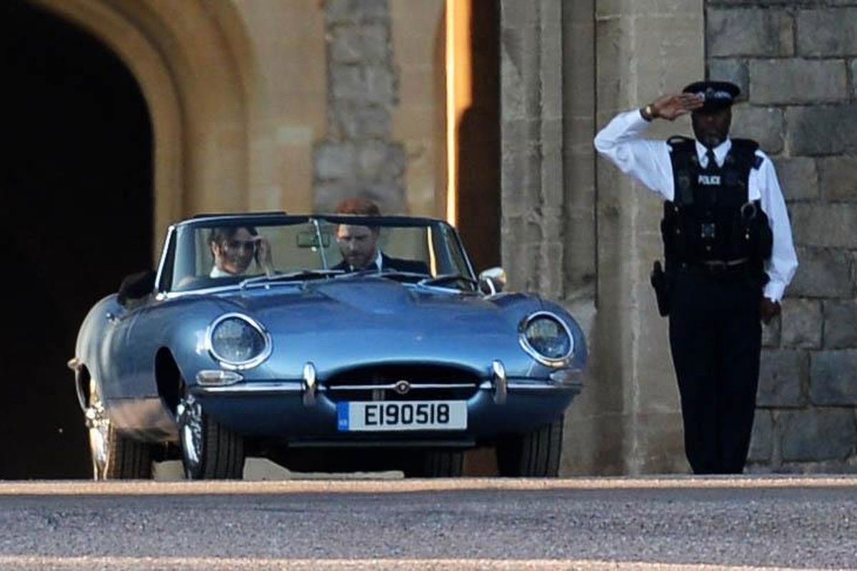 Pasangan Pangeran Harry dan Meghan Markle mengendarai Jaguar E-Type Concept Zero saat pergi ke acara pesta pernikahan mereka pada Sabtu (19/5/2018). 