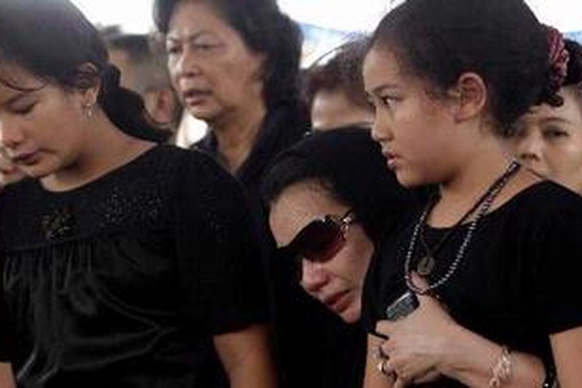 Reza Artamevia (tengah), mantan istri almarhum anggota Komisi V DPR-RI, Adjie Massaid didampingi kedua putrinya, Zahwa (kiri) dan Aaliya, saat pemakaman mantan suaminya di TPU Jeruk Purut, Jakarta Selatan, Sabtu (5/2/2011). Adjie Massaid meninggal dunia pada usia 43 tahun karena indikasi serangan jantung usai bermain bola. 