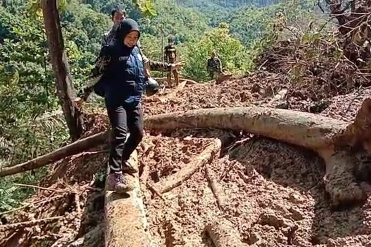 Meski dengan melewati jalan berlumpur dan diantara batang kayu, seorang Nakes yang masih berstatus honorer di Puskesmas Latimojong, Kabupaten Luwu, Sulawesi Selatan, tetap semangat menuju Puskesmas untuk melayani warga dalam pemberian vaksinasi, Senin (12/07/2021).