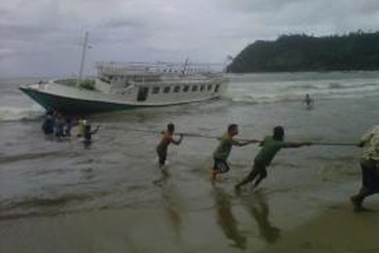 Warga sekitar pantai Sine, Tulungagung, Jawa Timur, Selasa (16/7/2013), menarik perahu pengangkut imigran asal Timur Tengah yang terdampar di Pantai tersebut. 