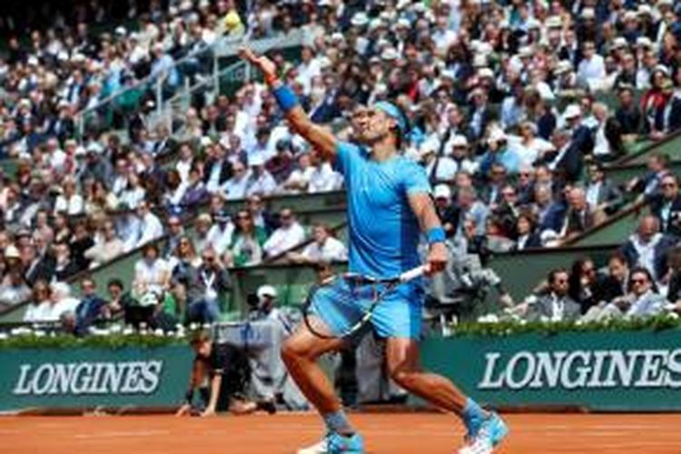 Petenis Spanyol, Rafael Nadal, melakukan servis saat bertemu Nicolas Almagro pada babak kedua Roland Garros di Paris, Kamis (28/5/2015). Nadal menang 6-4, 6-3, 6-1.