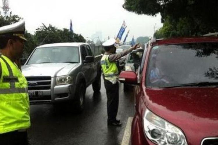 Polisi mengarahkan mobil yang hendak melintas di Jalan TB Simatupang untuk masuk jalan tol.