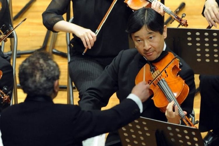 Naruhito ketika masih berstatus Putra Mahkota Jepang memainkan biola bersama orkstra dalam konser Gakushuin School Corporation di Tokyo pada April 2012.