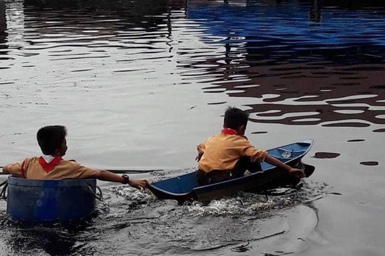 Dua murid SDN 011 Muara Wis menggunakan perahu kecil saat menuju sekolah di Desa Enggelam, Kecamatan Muara Wis, Kabupaten Kutai Kertanegara, Kaltim. 