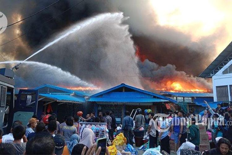 Puluhan kios di Pasar Pharaa Sentani Jayapura terbakar, Jumat (6/1/2023) sore. Mobil watercanon milik Polres Jayapura berupaya memadamkan api.  (Tribun Papua)