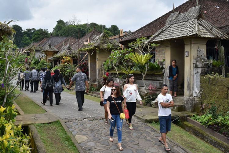 Sejumlah wisatawan mengunjungi Desa Adat Penglipuran di Kubu, Kabupaten Bangli, Bali, Kamis (19/7/2018). Desa yang pernah dinobatkan sebagai salah satu desa terbersih dunia ini kini menerapkan sistem tiket elektronik atau e-ticket untuk tiket masuk pengunjung.