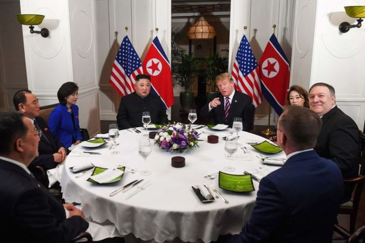 Presiden Amerika Serikat Donald Trump dan pemimpin Korea Utara Kim Jong Un duduk bersama bersama perwakilan lain dari masing-masing negara untuk makan malam di Hotel Sofitel Legend Metropole di Hanoi, Vietnam (27/2/2019). (AFP/SAUL LOEB).