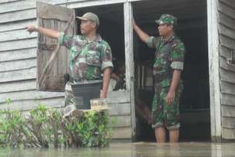 Danramil Indralaya Kapten Widodo bersama anggotanya meninjau salah satu rumah warga yang terendam banjir di KTM Sungai Rambutan