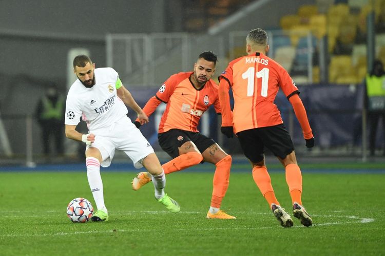 Karim Benzema (kiri) berduel dengan Dentinho (kanan) dalam laga matchday kelima Grup B Liga Champions, Shakhtar Donetsk vs Real Madrid, di Stadion Olimpiade Kiev, Rabu (2/12/2020) dini hari WIB. 