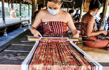 Pengrajin sedang membuat kain tenun gringsing. 