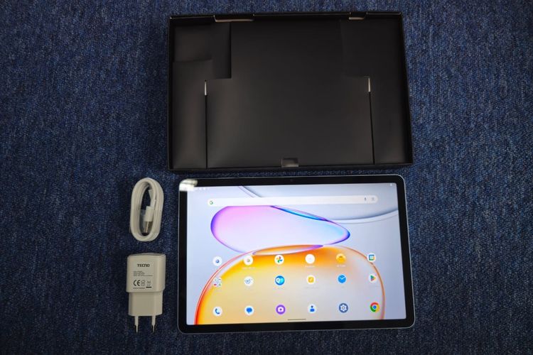 Tablet Tecno Megapad SE dilengkapi dengan kabel charger, adaptor, SIM ejector, dan kartu garansi di dalam kotak kemasan.