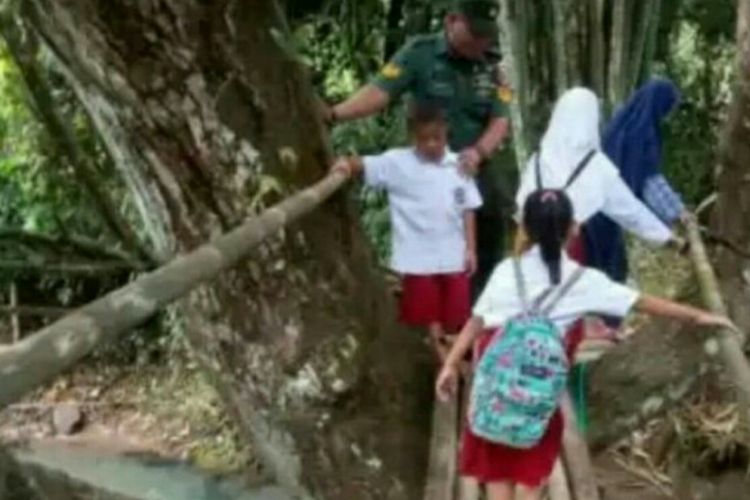 Murid-murid SD ke sekolah melintasi jembatan bambu.