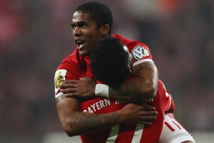 Douglas Costa dan David Alaba merayakan mencetak gol penentu kemenangan Bayern Muenchen atas Wolfsburg pada partai babak 16 besar DFB Pokal di Allianz Arena, Selasa (7/2/2017).