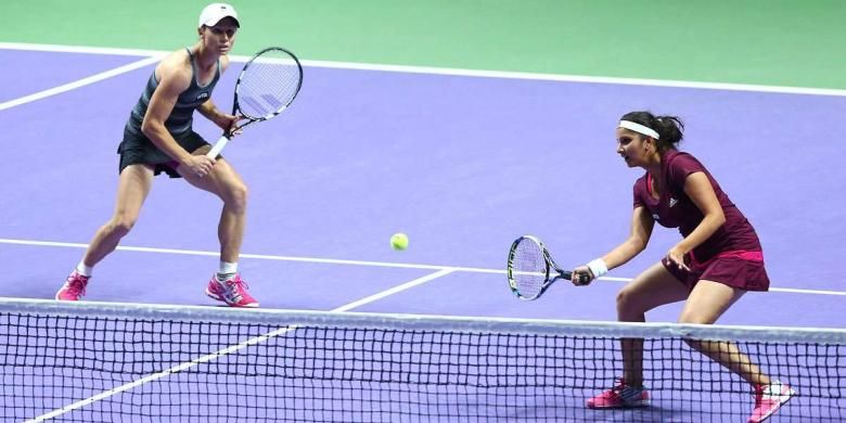 Pasangan ganda putri, Cara Black (kiri)/Sania Mirza, mengembalikan bola dari pasangan Hsieh Su-wei/Peng Shuai, pada final ganda putri WTA FInal di ingapore Indoor Stadium, Minggu (26/10/2014). Black/Mirza menang 6-1, 6-0.