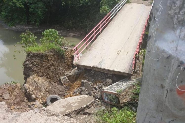 Petugas kepolisian sedang mengalihkan kendaraan akibat jembatan ambles di Kampung Cicadas, Desa Babakan Madang, Kecamatan Babakan Madang, Kabupaten Bogor, Jawa Barat, Kamis (22/9/2022).