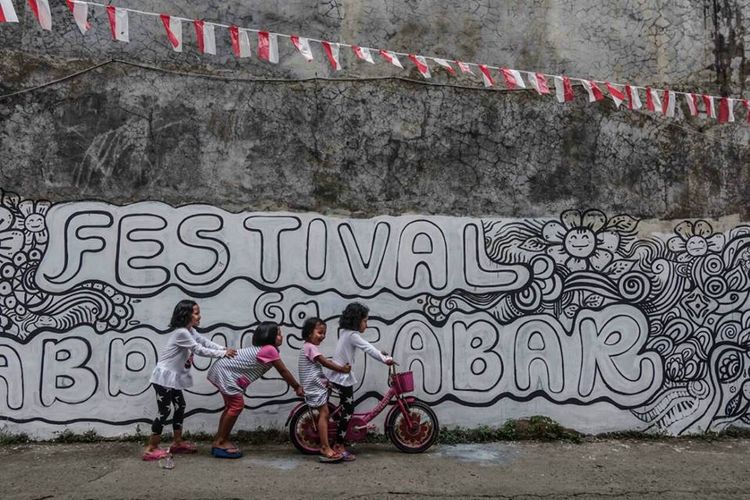 Anak-anak sedang bermain-main di depan mural bertuliskan Festival Gang Abdul Jabar yang akan diisi warna dan ornamennya oleh teman-teman sebayanya pada sore hari 19 Agustus 2017.