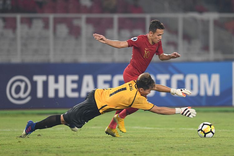 Pesepak bola Indonesia Egy Maulana Vikri (atas) mencoba mengecoh penjaga gawang Taiwan Li Guan-Pei dalam laga Grup A Piala Asia U-19 di Stadion Utama Gelora Bung Karno, Jakarta, Kamis (18/10/2018). Indonesia menang dengan skor 3-1.  