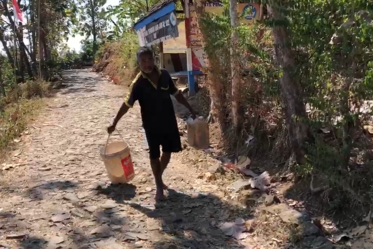 Salah satu warga Desa Wates, Kecamatan Slahung, Kabupaten Ponorogo, Jawa Timur mengangkat air bersih yang ditimba dari sumur dalam. Krisis air bersih melanda tiga dukuh di desa itu dua bulan terakhir. 