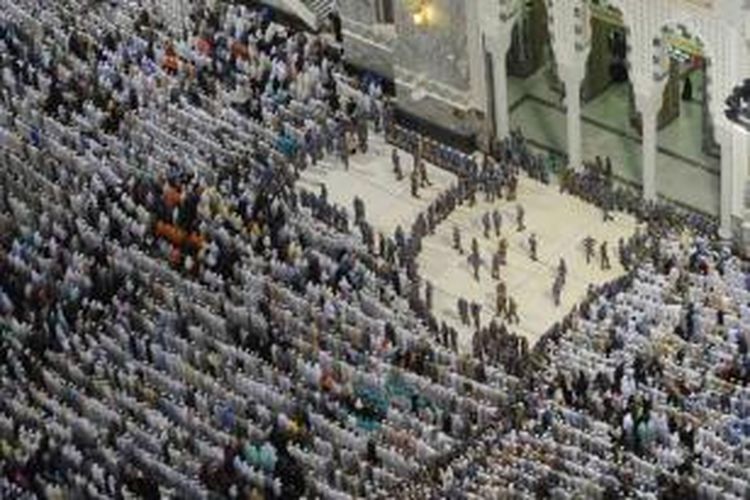 Petugas keamanan berjaga di tengah umat Muslim yang beribadah di Masjidil Haram, Kota Mekkah, Arab Saudi, bagian dari kegiatan haji, 8 Oktober 2013. Lebih dari dua juta muslim tiba di kota suci ini untuk ibadah haji tahunan.