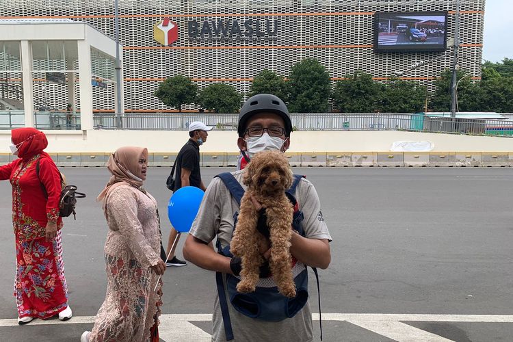 Jhony warga asal Bekasi, Jawa Barat, membawa anjing peliharaannya bernama Jo ke area Hari Bebas Kendaraan Bermotor (HBKB) atau car free day di Jalan MH Thamrin, Jakarta Pusat, Minggu (6/11/2022).