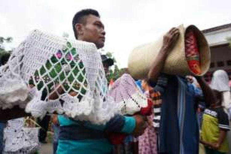 Keluarga membawa bantal dan tikar saat mengarak pengantin dalam tradisi jolang di Desa Olehsari, Kabupaten Banyuwangi, Jawa Timur, Minggu (27/11/2016).