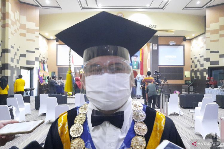 Rektor Universitas Lambung Mangkurat (ULM) Prof Sutarto Hadi mengenakan masker dan pelindung wajah saat gelaran wisuda.