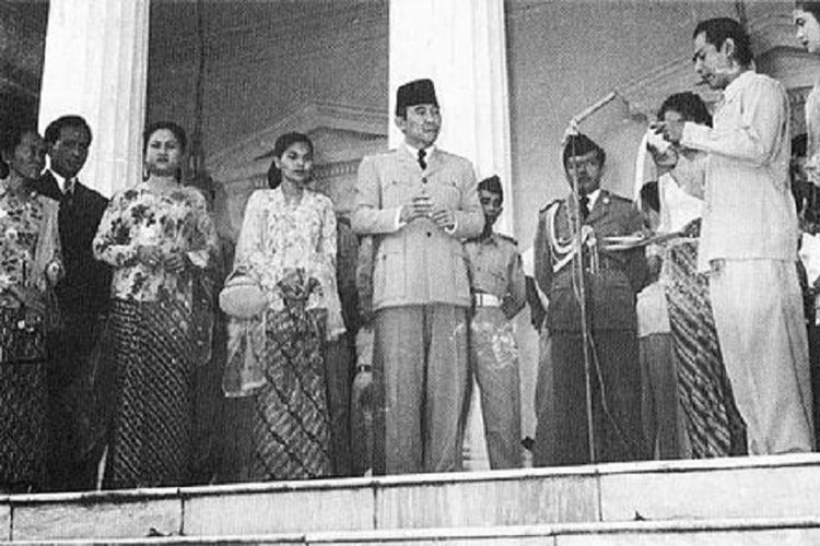 Soekarno di depan Istana Merdeka menyimak seorang aktor film membaca puisi (1956).