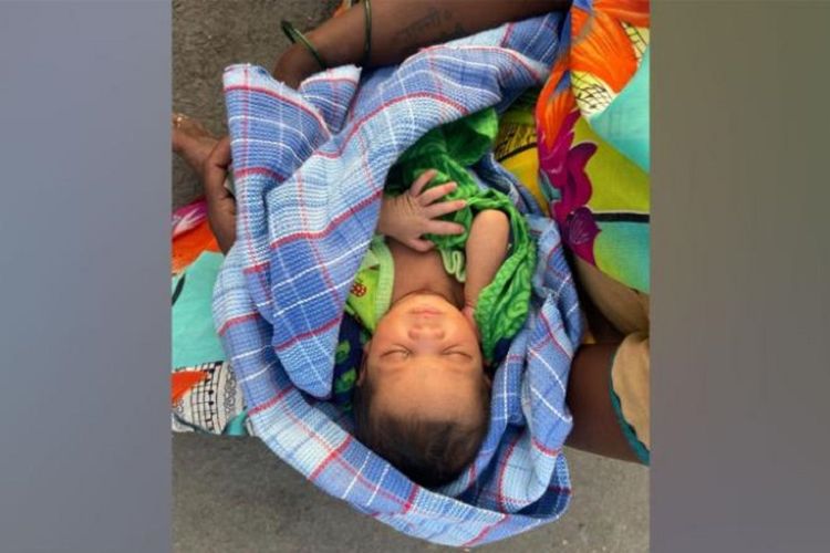 Foto yang diambil petugas perbatasan Bijasan, Madhya Pradesh, India, Kavita Kanesh, menunjukkan seorang bayi dalam dekapan ibunya. Ibu bayi itu melahirkan di tengah perjalanan mereka pulang kampung, dan berjalan 160 km sembari membawa bayinya.