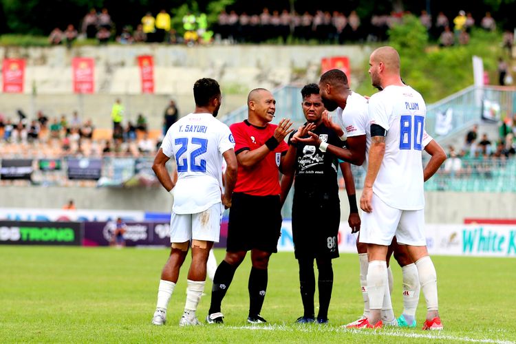 Wasit Oki Dwi Putra saat memberi penjelasan kepada pemain PSM Makassar saat pertandingan pekan ke-26 Liga 1 2022-2023 melawan Persebaya Surabaya yang berakhir dengan skor 0-1 di Stadion Gelora Joko Samudro Gresik, Jumat (24/2/2023) sore. 