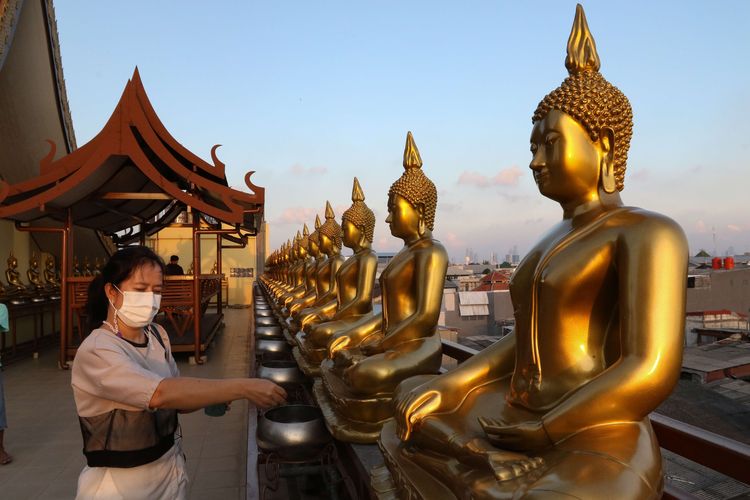 Umat memasukkan uang koin di depan patung Budha di Vihara Hemadhiro Mettavati, Cengkareng, Jakarta Barat, Rabu (26/5/2021). Umat Budha merayakan Hari Tri Suci Waisak.