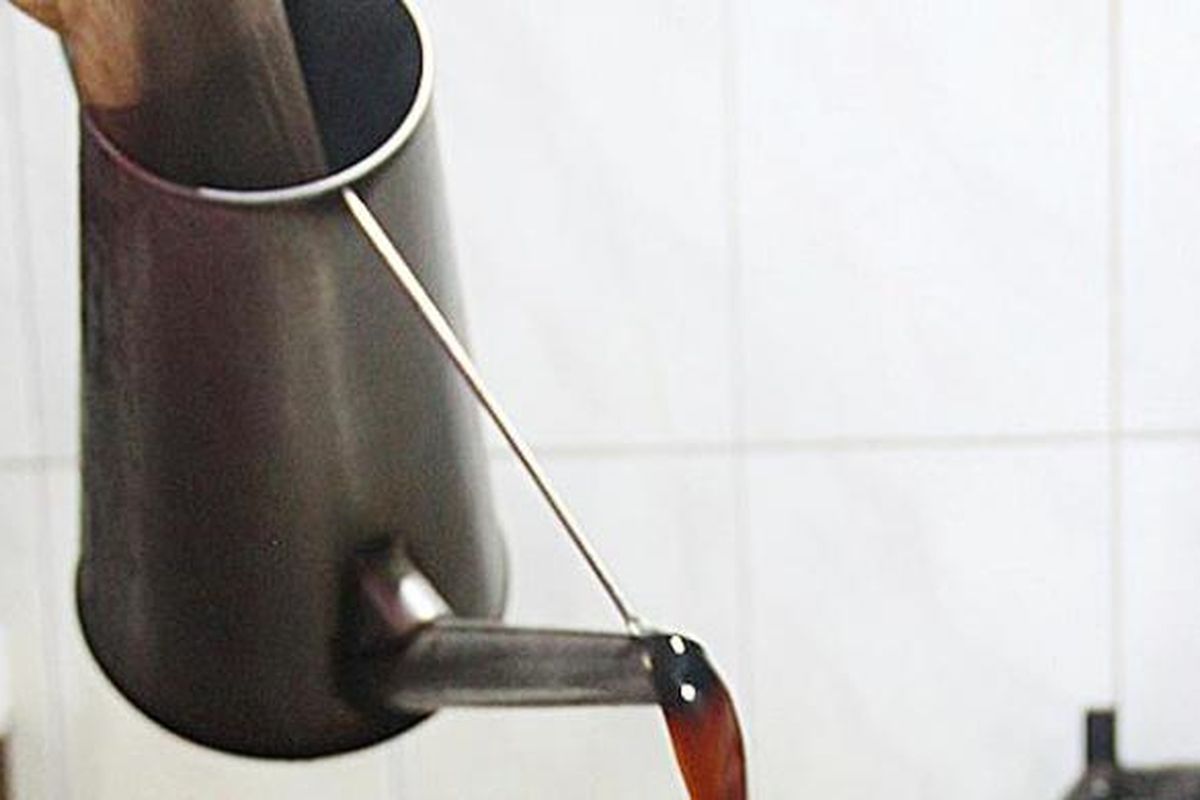 Kopi o atau kopi hitam yang telah diseduh dituang ke cangkir.
