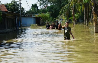 Aktivitas masyarakat saat banjir masih menggenangi Jalan Jalan Khairil Anwar, Kelurahan Pekan Tanjung Pura, Kecamatan Tanjung Pura, Kabupaten Langkat, Sumatera Utara pada Jumat (5/12/2025). 