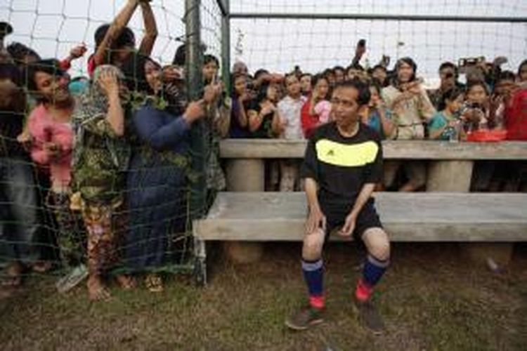 Warga antusias melihat Gubernur DKI Jakarta yang juga presiden terpilih Joko Widodo alias Jokowi bermain bola di acara Pesta Rakyat Waduk Pluit, di Lapangan Bola Waduk Pluit, Jakarta Utara, Minggu (17/8/2014). Selain bermain bola, Jokowi juga sempat ikut serta dalam lomba balap karung bersama warga di Taman Waduk Pluit. 