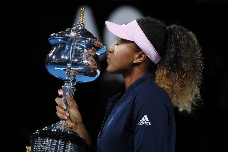 Petenis Jepang, Naomi Osaka, mencium trofi Australian Open 2019. Petenis 21 tahun ini meraih gelar grand slam keduanya setelah mengalahkan Petra Kvitova (Ceko) di laga final, Sabtu 26 Januari 2019.