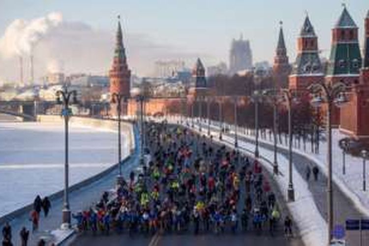Peserta aksi parade bersepeda musim dingin di Kota Moskwa, Rusia mengawali start di sisi tembok Kremlin, sejajar dengan Sungai Moskwa yang membeku, Minggu (8/1/2017).  Mereka bersepeda menembus suhu minus 27 derajat celcius.