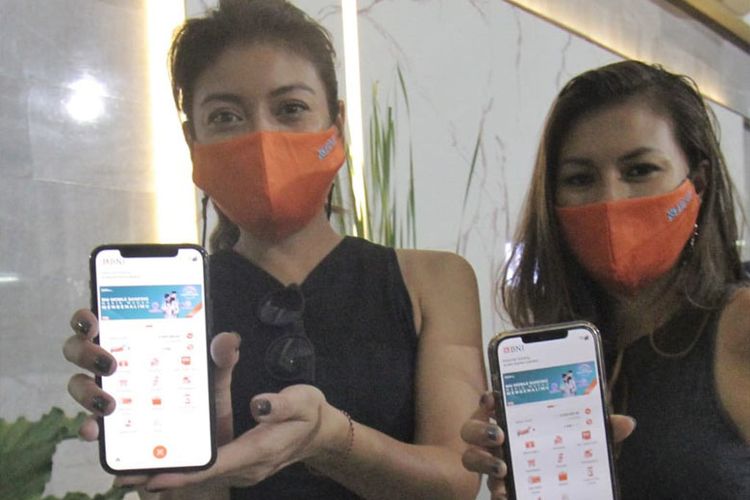 Marianne Rumantir (kanan) dan Sigi Wimala (kiri) menunjukkan aplikasi BNI Mobile Banking.