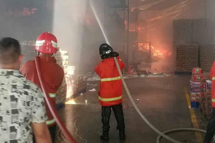 Petugas damkar saat memadamkan api di dalam gudang deterjen milik PT Wings di Gabek, Pangkal Pinang, Jumat (24/5/2019).