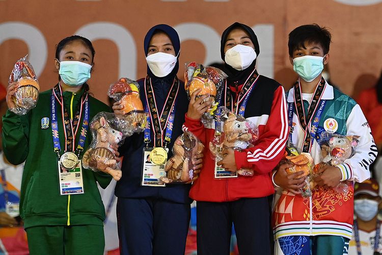 Judoka Jawa Barat Anggun Nuraijjah (kedua kiri) berfoto dengan judoka Jawa Timur Luh Eka Meidiani (kiri), judoka Bali Tiwi Anjelina (kedua kanan), dan judoka Papua Nirza (kanan), usai pengalungan medali nomor 45 kilogram cabang judo PON Papua di Graha Eme Neme Yauware, Timika, Kabupaten Mimika, Rabu (29/9/2021). Anggun menang dalam babak final sekaligus meraih medali emas, sementara medali perak diraih Luh Eka dan medali perunggu diraih  medali perunggu diraih Tiwi Anjelina serta Nirza.