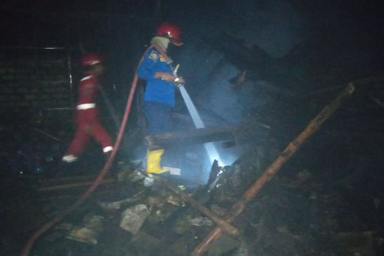 Petugas berusaha memadamkan api yang membakar rumah Kasmuah dan kandang hewan, di Desa Datinawong, Kecamatan Babat, Lamongan.
