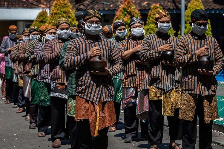 Pasukan Patangpuluh Kendi Kasepuhan Girikusumo dengan mengenakan masker mengirab kendi berisi air dari sumur berkah Girikusumo sebagai simbol berkah alam dalam prosesi Tradisi Kirab Sura Girikusumo di Desa Banyumeneng, Mranggen, Demak, Jawa Tengah, Kamis (20/8/2020). Tradisi menyambut tahun baru Islam 1 Muharram 1442 Hijriah atau satu Sura yang biasanya dihadiri ribuan warga itu, kali ini hanya dihadiri keluarga besar Kasepuhan Girikusumo dengan menerapkan sejumlah protokol kesehatan guna mencegah penyebaran Covid-19.