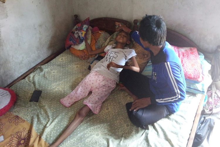 Silfi Qumairoh (14), gadis asal Kedungmaling, Sooko, Kabupaten Mojokerto Jawa Timur, terbaring didampingi ayahnya, Mohammad Gozali, Rabu (9/10/2019).