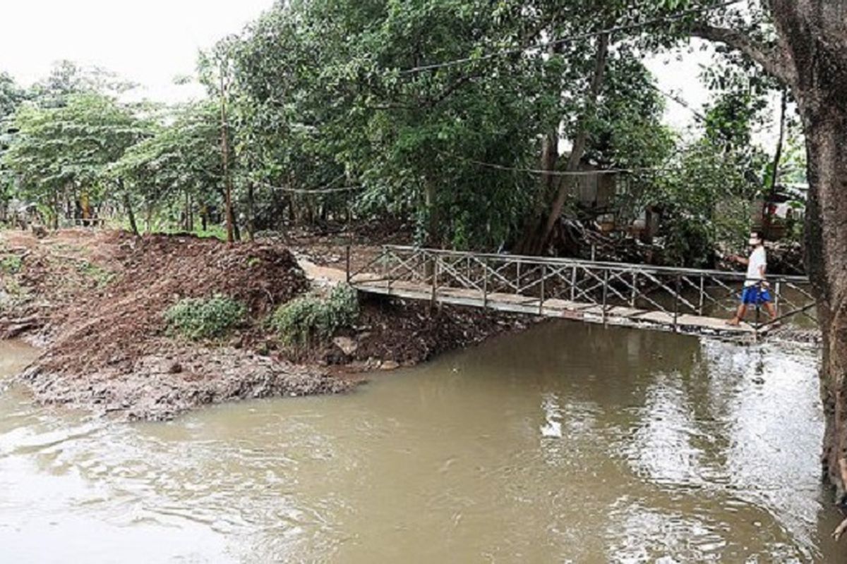 Pembangunan turap yang memagari Kali Sunter sampai saat ini masih belum rampung seperti terlihat di Cipinang Melayu, Jakarta Timur, Senin (10/4). Pada sisi kanan jembatan, sungai menyempit dan pembangunan turap belum dilanjutkan karena terkendala pembebasan lahan. Normalisasi Kali Sunter sepanjang 20 kilometer pada tahun 2011-2014 baru tercapai 60 persen. 