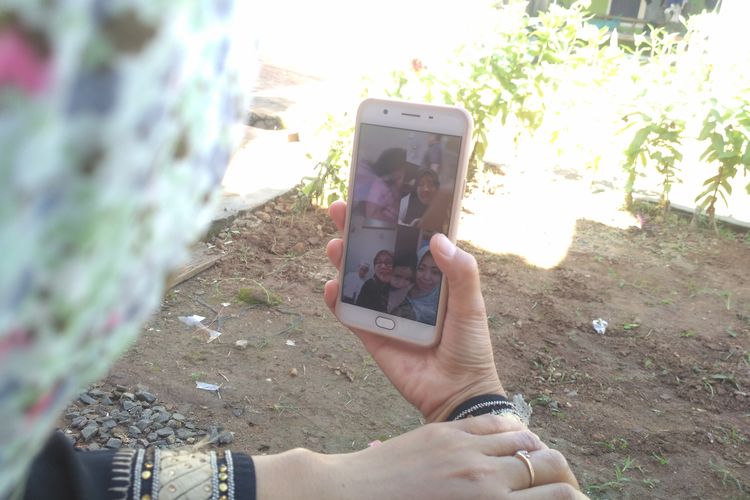 Annavia (36) warga Kampung Sinar Banten berlebaran secara video call dengan tiga kakak kandungnya, Minggu (24/5/2020). Ibu dua anak ini tidak mudik ke Palembang seperti lebaran tahun lalu. 