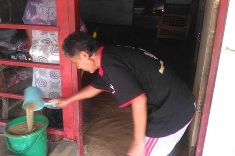 Muhklas, warga Sawah besar RT 02 RW 05, Kecamatan Gayamsari, Kota Semarang, sedang menguras air di dalam rumah menggunakan ember, Selasa (14/2/2017). 